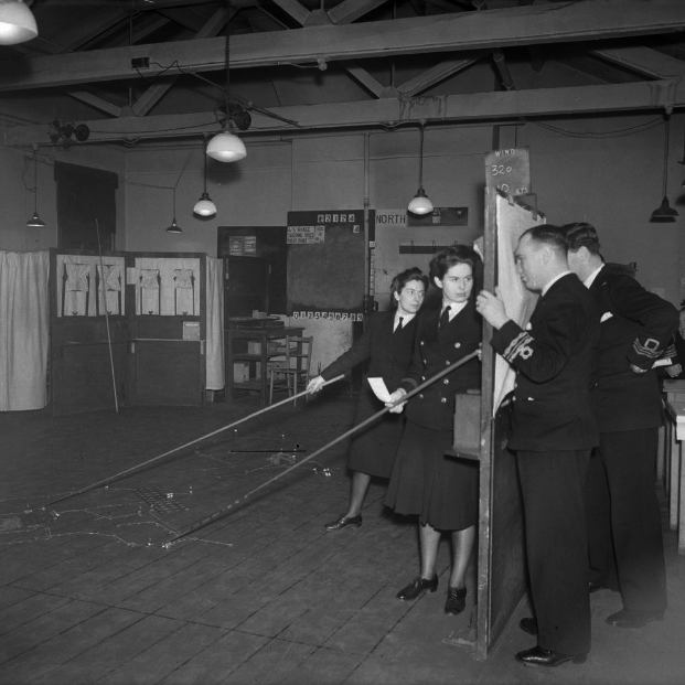 WATU Wargame of 1942 - public domain via wikicommons A naval wargame conducted at the Western Approaches Tactical Unit (WATU) in Liverpool during World War II. The male officers on the right ar